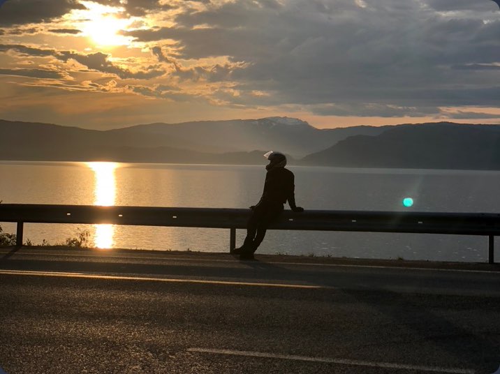 Photo of rider by the side of the road at sunset
